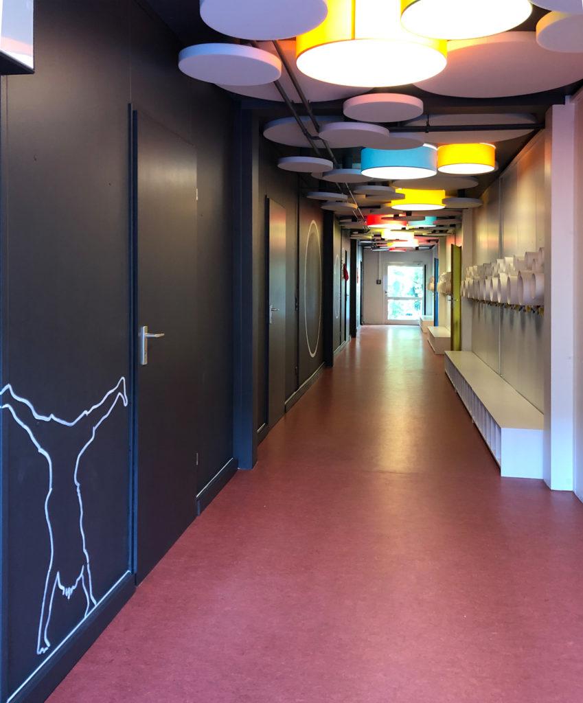 Flur mit bunten Leuchten und schwarzer Wand